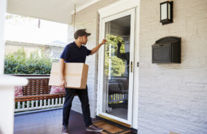 Courier Knocking On Door Of House To Deliver Package